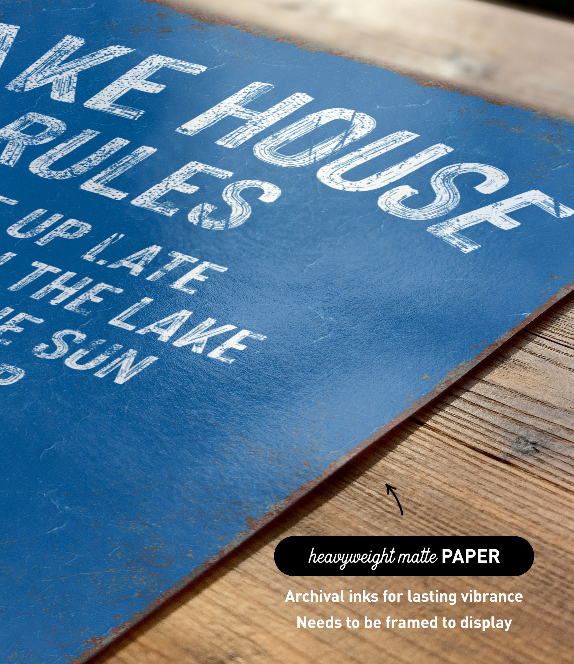 a close-up of a blue sign with white text, placed on a wooden surface.