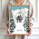 A person is holding a framed picture of a couple on a ski lift, surrounded by snow-covered trees, with the word "APRÈS" visible.