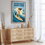 a framed poster of a woman surfing with the text "REACH HAIR DON'T CARE" on it, hanging on a wall above a wooden dresser.
