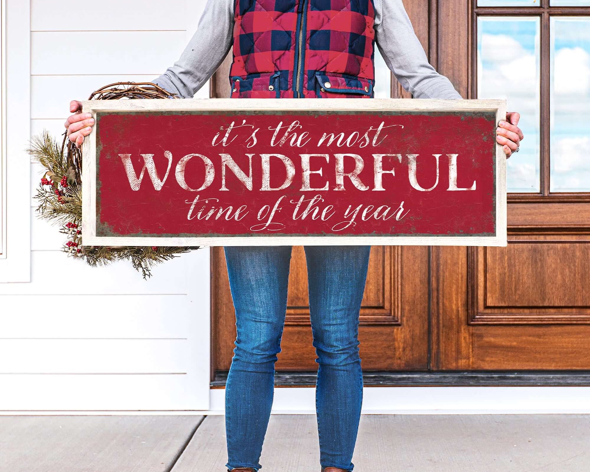 a woman holding a sign that says it's the most wonderful time of the