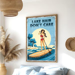 a framed poster of a woman paddleboarding on a lake, with the text "LAK E HAIR DON'T CARE" written on it.