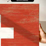 a hand holding a piece of wood with a cross painted on it