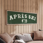 a cozy living room with a green sign that reads "APRÈS SKI" hanging on the wall above a couch.