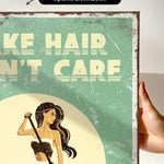 The image is a vintage-style poster with a woman in a bathing suit, holding a towel, and the text "HAIR, N'T CARE" prominently displayed.