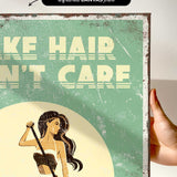The image is a vintage-style poster with a woman in a bathing suit, holding a towel, and the text "HAIR, N'T CARE" prominently displayed.