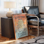a framed sign with beach rules, placed on a wooden floor next to a black leather chair.