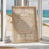 A wooden sign with beach rules posted in a room with a view of the ocean through a window.
