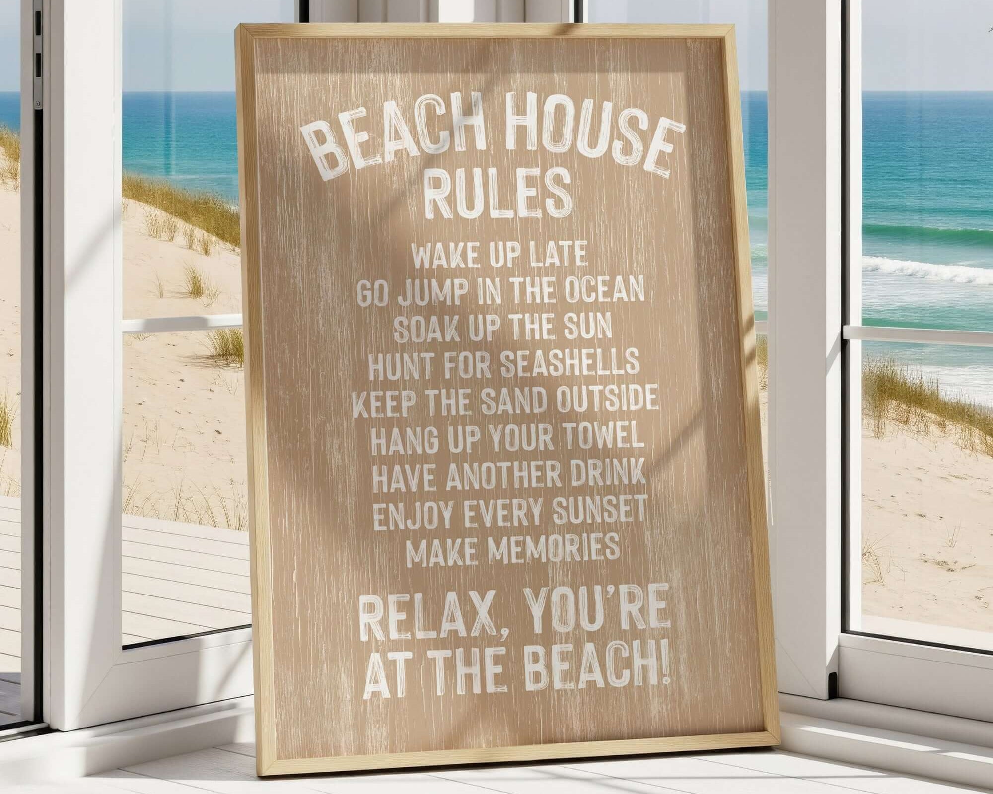 A wooden sign with beach rules posted in a room with a view of the ocean through a window.