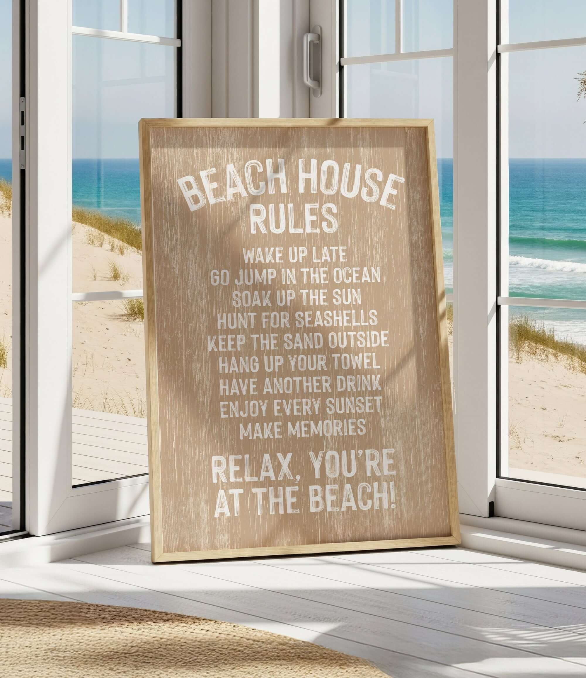 A wooden sign with beach rules posted in a room with a view of the ocean through a window.
