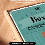 a close-up view of a framed artwork with a teal background and text that reads "SOAP and BUB".