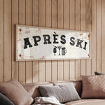 a wooden wall with a framed sign that reads "APRÈS SKI", accompanied by a beer mug and a wine glass icon.