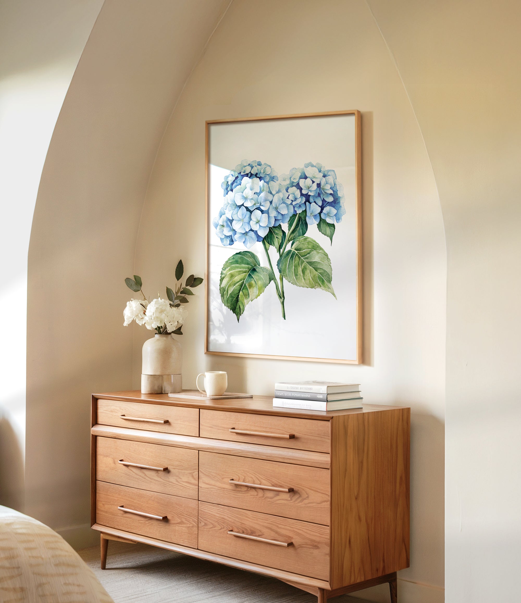a wooden dresser with a framed painting of blue hydrangeas hanging on the wall above it. The dresser has six drawers and a vase of white flowers on top.