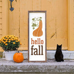 a black cat sitting next to a sign that says hello fall