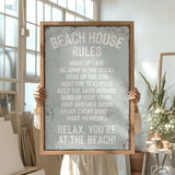 a person holding a sign that says beach house rules