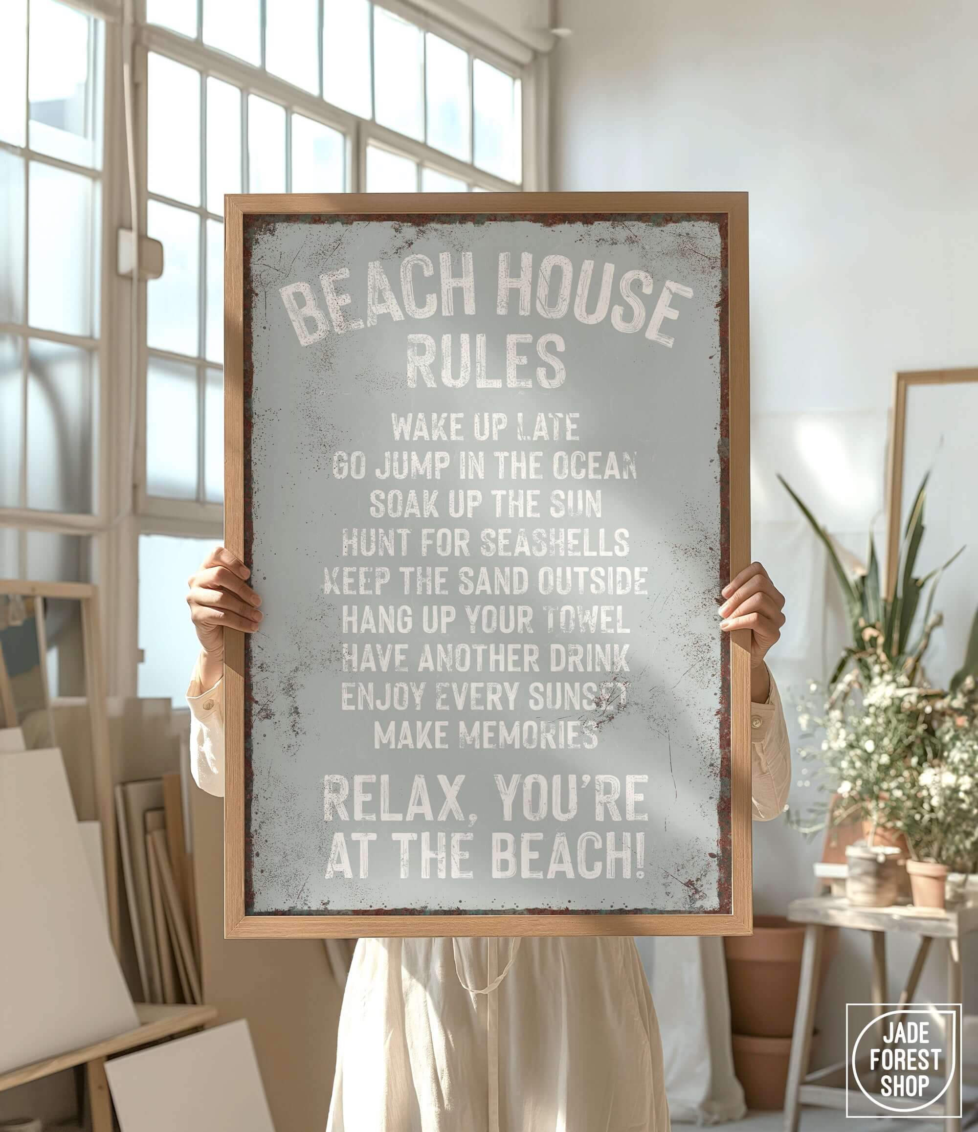 a person holding a sign that says beach house rules