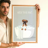 A man is holding up a framed poster with a dog sitting in a bathtub filled with bubbles, accompanied by the text "WASH YOUR PAWS".