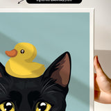 a black cat with yellow eyes and a yellow rubber duck perched on its head.