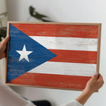a person holding a wooden sign with a flag painted on it