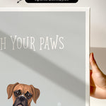 a brown dog with a friendly expression, sitting next to a gray background with the text "Witch Your Paws" written on it.