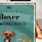 a hand holding a framed print with a vintage-style illustration of a boxer dog.