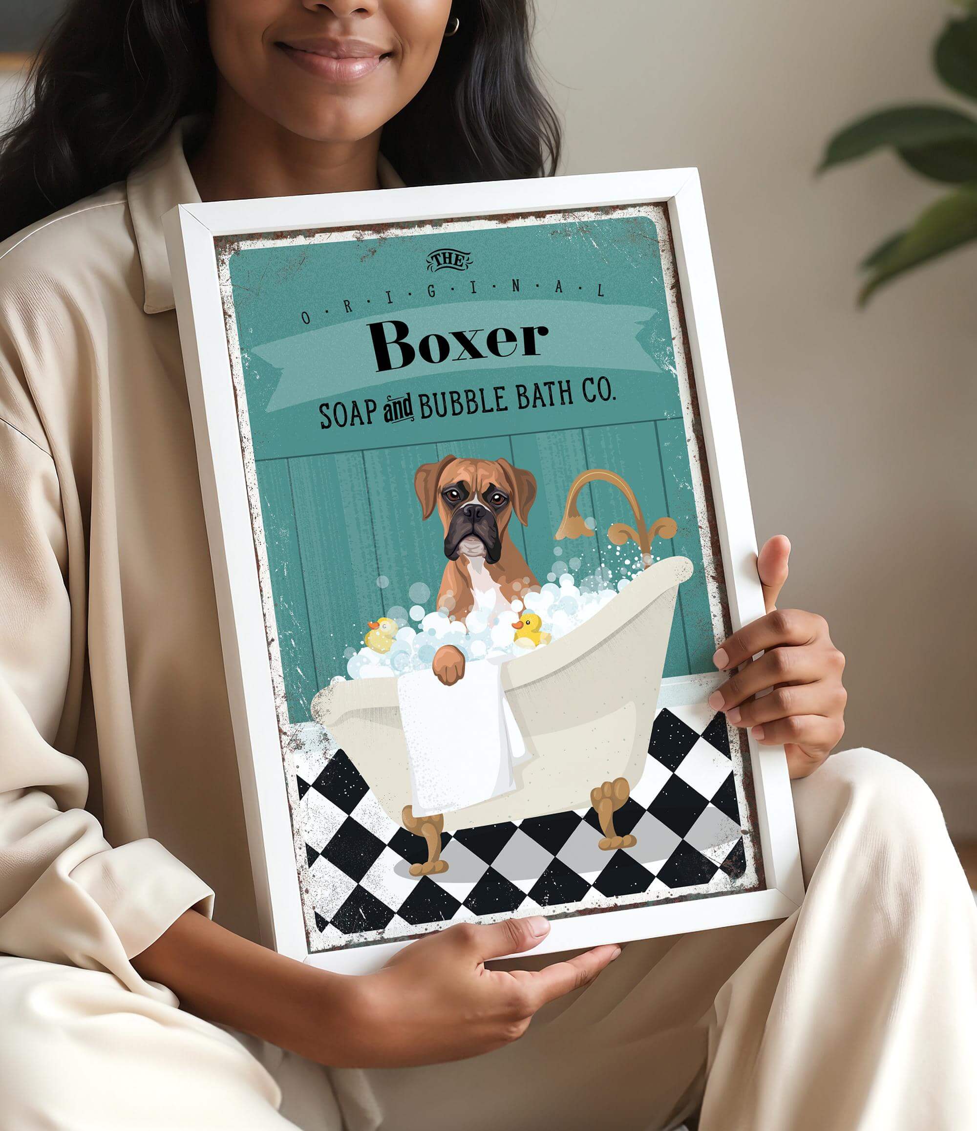 A woman is holding a framed picture of a dog in a bathtub, with a sign that reads "Boxer SOAP & BUBBLE BATH CO."