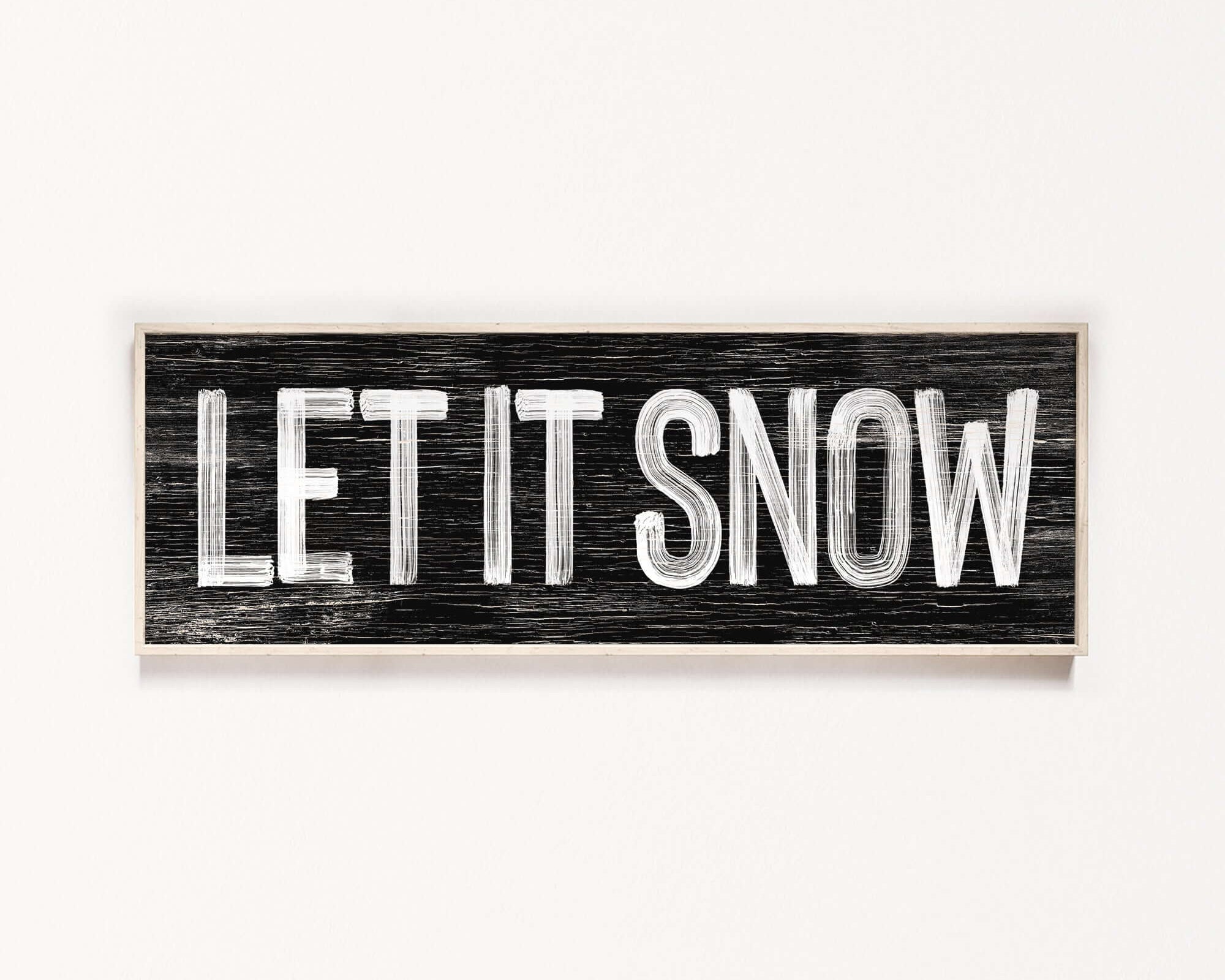 a wooden sign that says let it snow