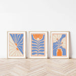 three framed art pieces on a wooden floor