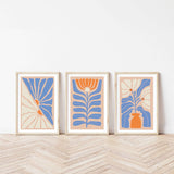 three framed art pieces on a wooden floor