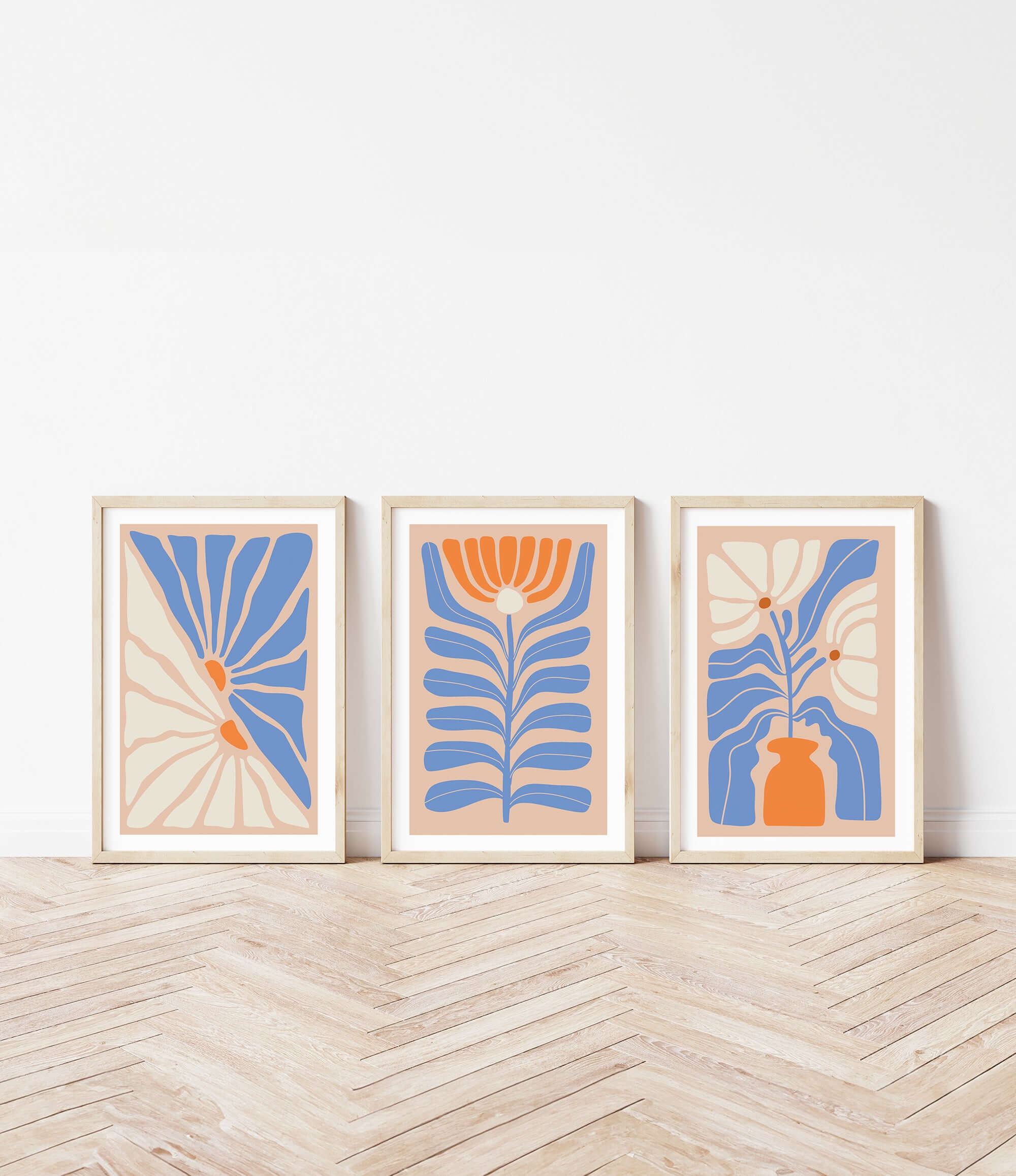 three framed art pieces on a wooden floor