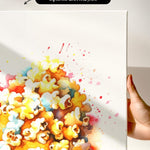 The image is a watercolor painting of a pile of popcorn, with splashes of color and a hand holding the canvas.