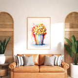 a cozy living room with a brown leather sofa adorned with striped pillows. Above the sofa, a framed watercolor painting of a colorful cupcake with a flower on top is displayed on the wall. The room is decorated with potted plants and wooden shutters, creating a warm and inviting atmosphere.