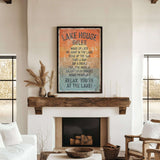 a cozy living room with a fireplace, a wooden mantel, and a framed sign that reads "LAKESHORE RULES" hanging above it.