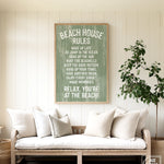 Cozy couch with white pillows in a beach house, topped by the Beach House Rules Sign in painted wood with seagrass, adding the perfect coastal wall art above.