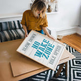 a woman holding a sign on top of a table
