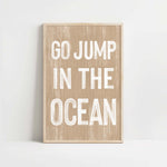 a wooden sign that says go jump in the ocean