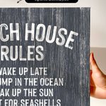 a hand holding a canvas print with the text "CHEACH HOUSE RULES" written on it.
