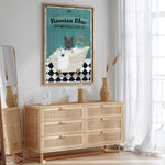 a poster of a cat in a bathtub, with the text "Russian Blue SOAP & BUBBLE BATH CO." The poster is hanging on a wall above a wooden dresser with drawers.