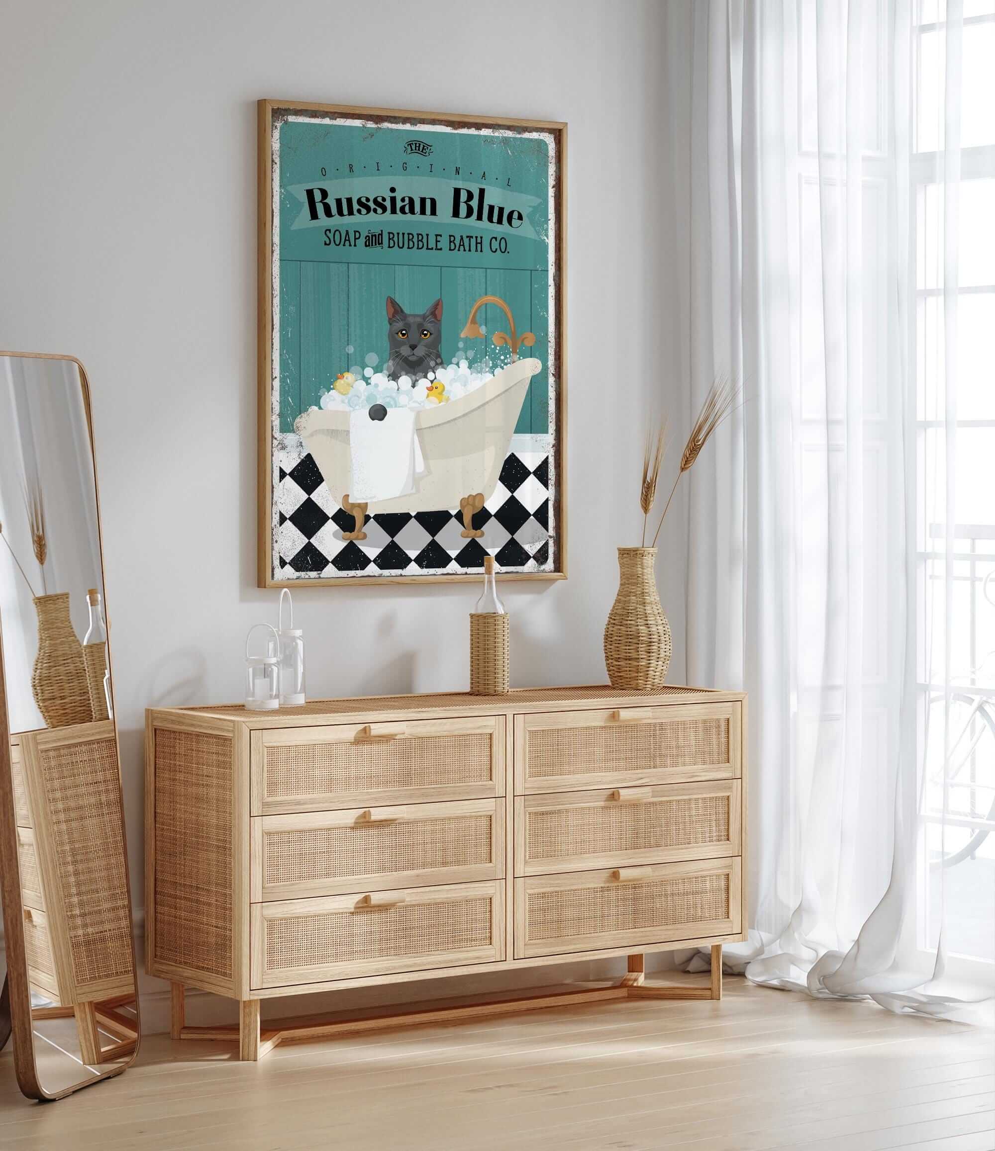 a poster of a cat in a bathtub, with the text "Russian Blue SOAP & BUBBLE BATH CO." The poster is hanging on a wall above a wooden dresser with drawers.