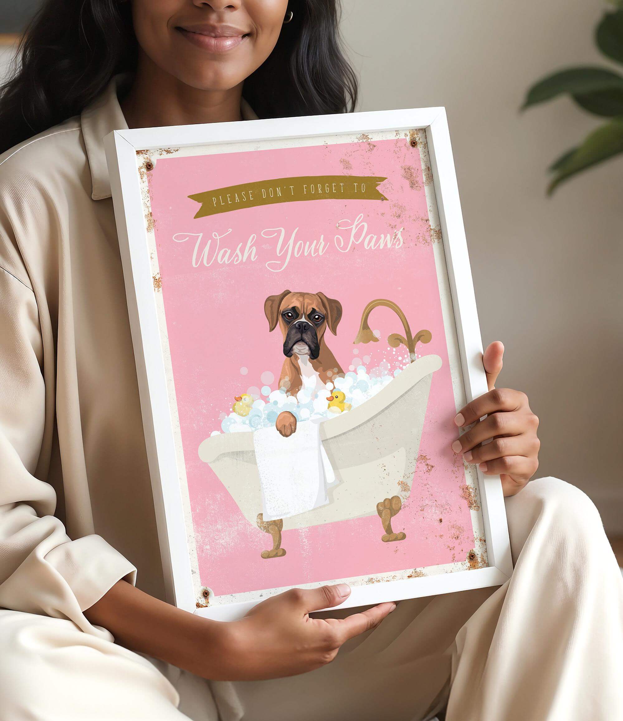 A woman is holding a framed poster with a cartoon image of a dog sitting in a bathtub, surrounded by bubbles.