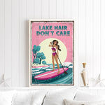 a framed poster with a woman paddleboarding on a lake, with the text "LAKESHAIR DON'T CARE" written on it.