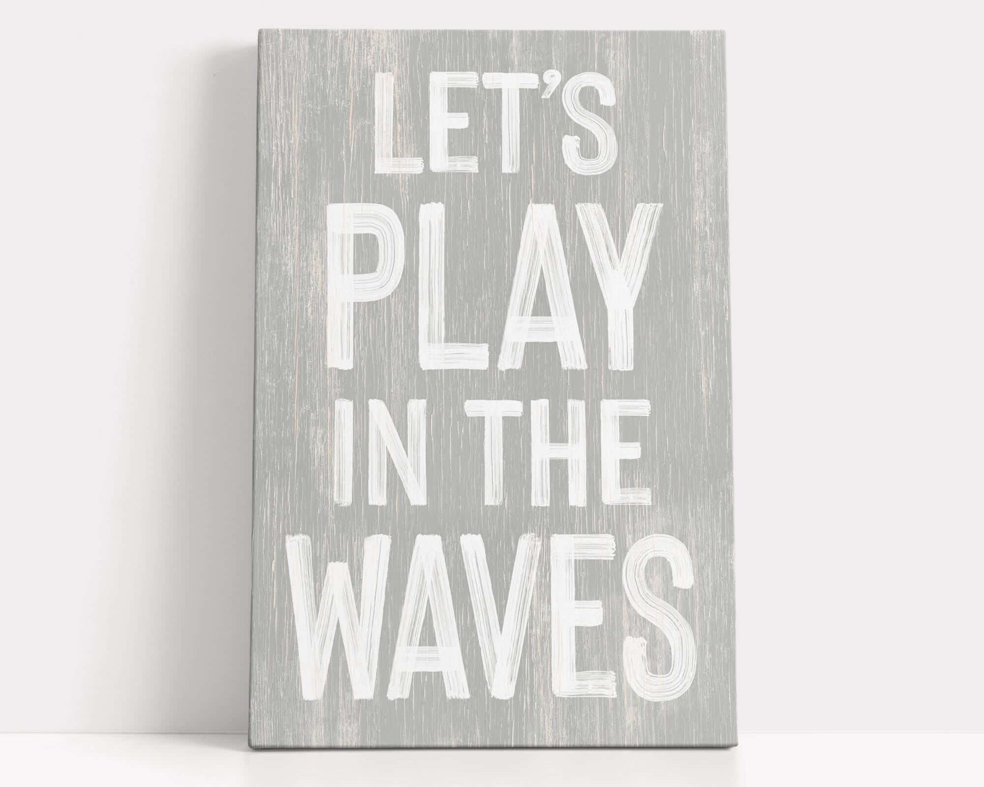 a wooden sign that says let's play in the waves