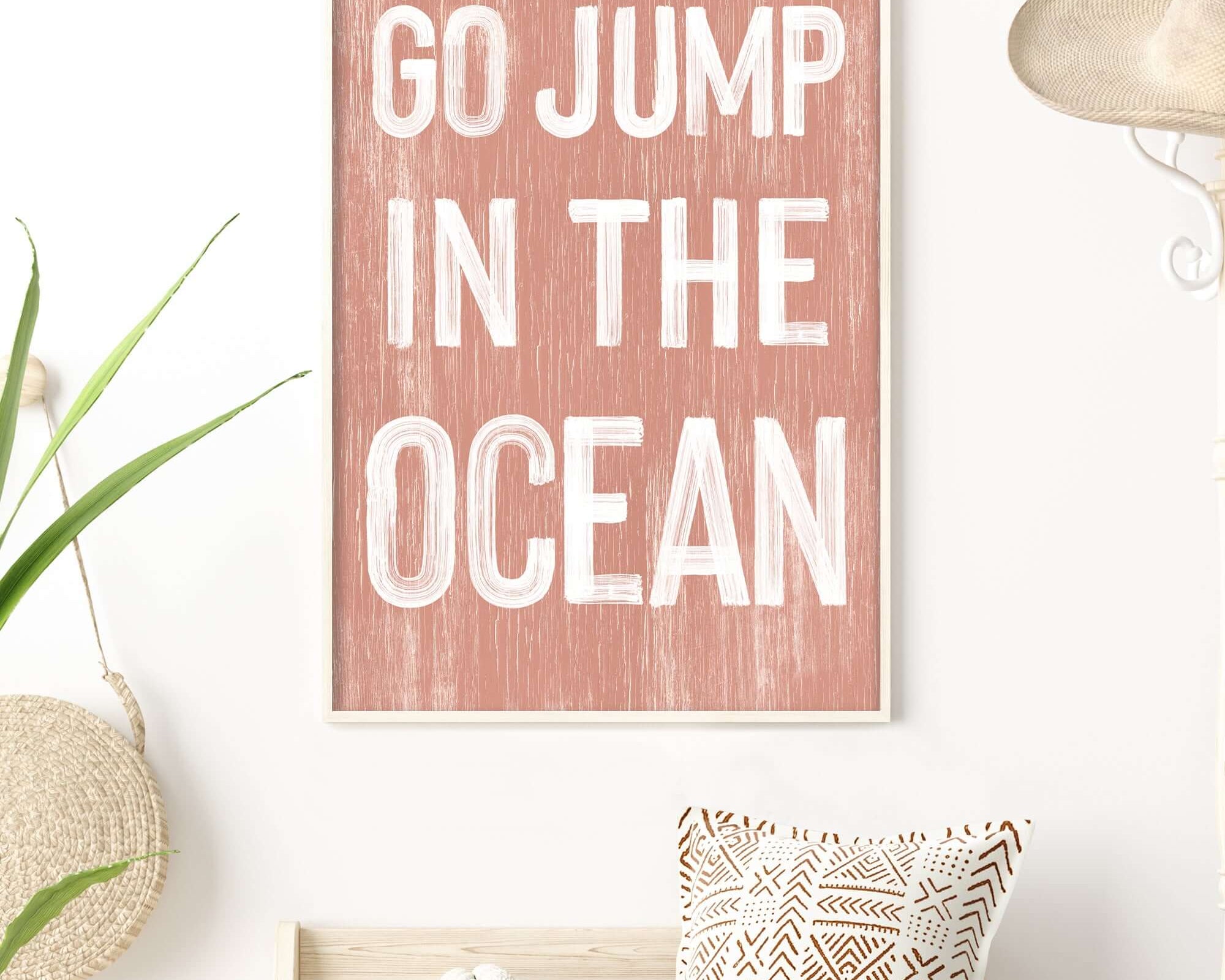 a pink and white poster with the words go jump in the ocean