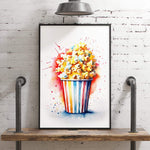 A framed watercolor painting of a bucket of popcorn is displayed on a wooden shelf against a white brick wall.