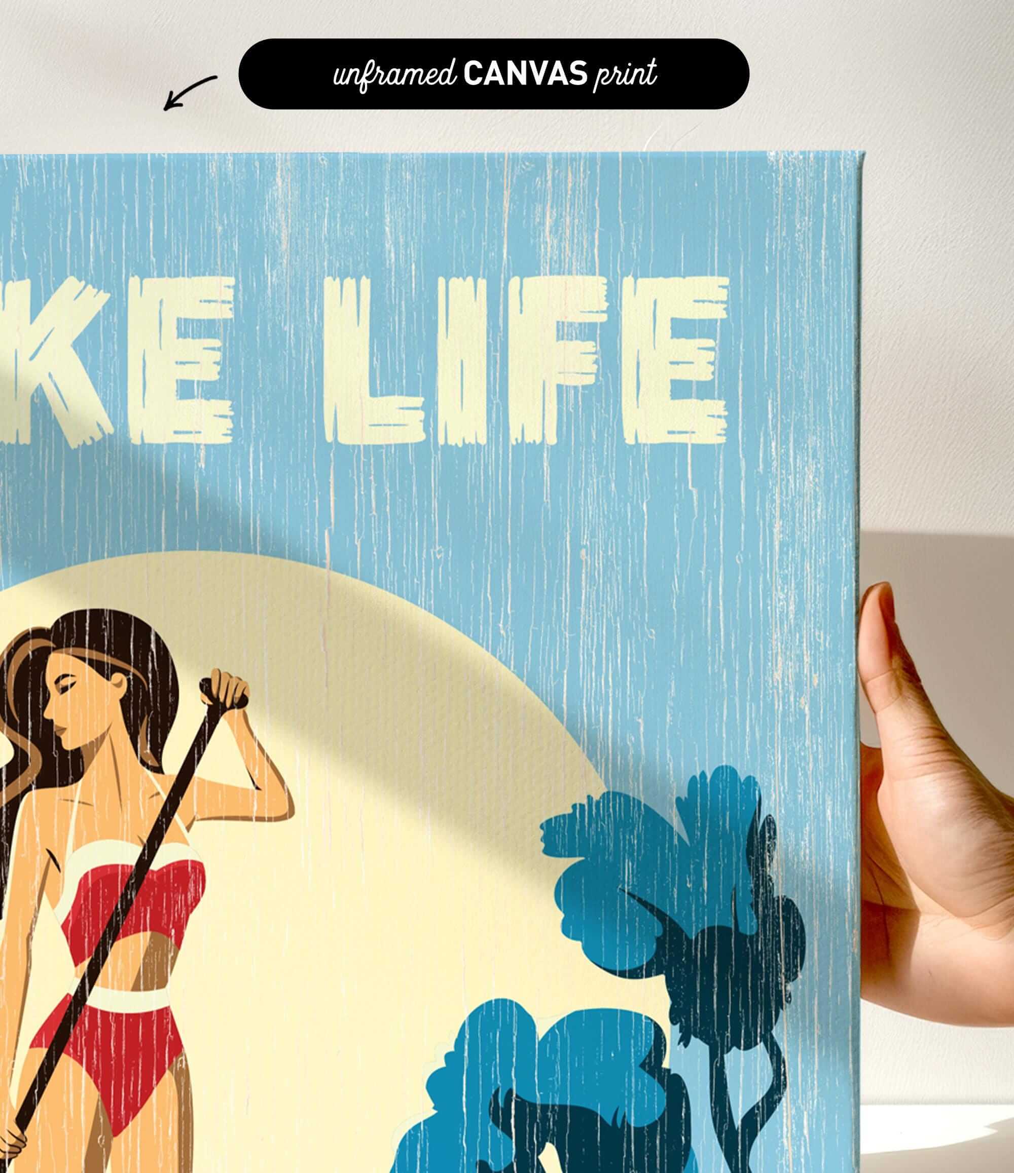 a hand holding a framed print with a beach scene and a woman in a red bikini.