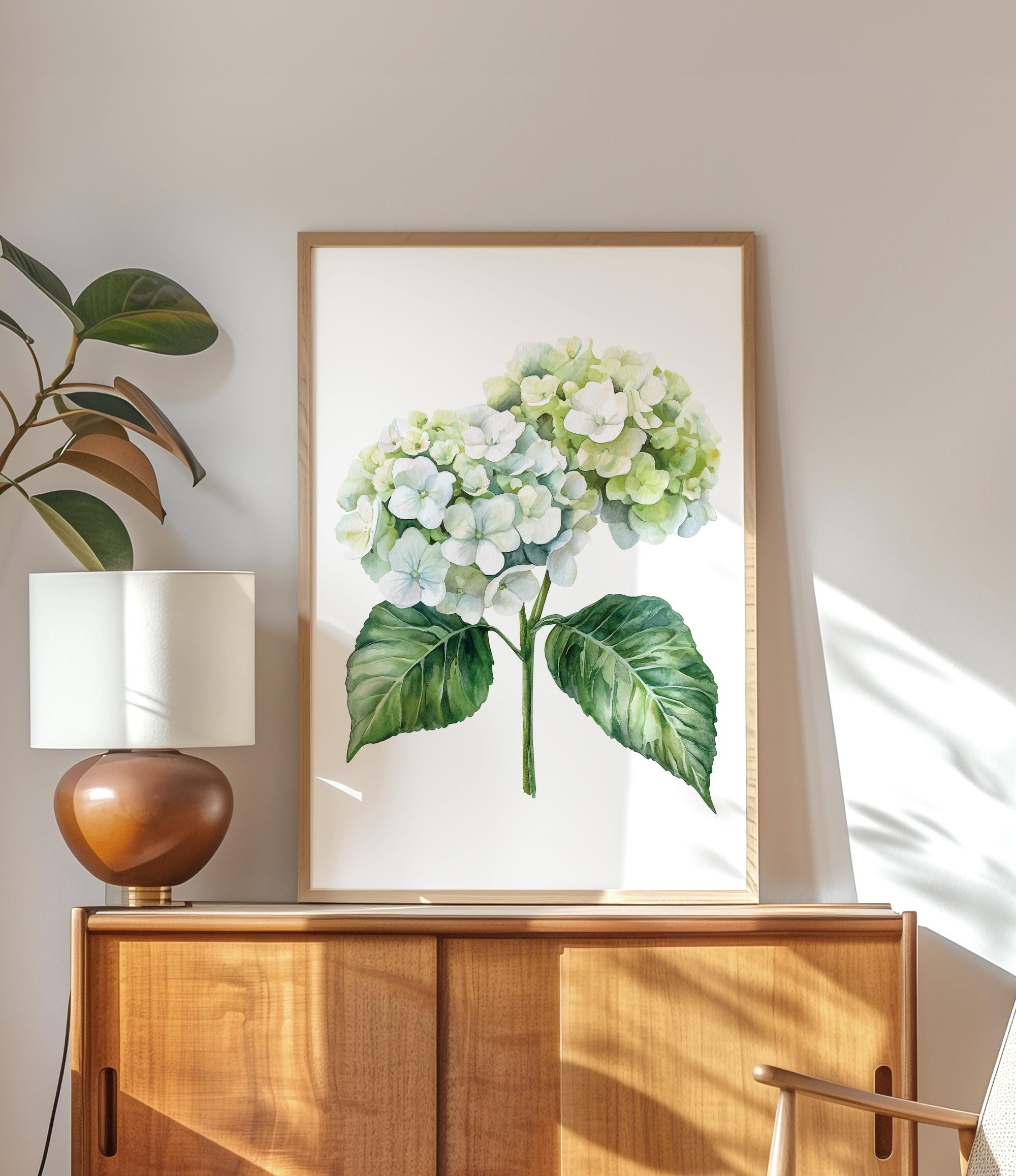 a wooden cabinet with a framed painting of a white hydrangea flower hanging on it. The painting is placed on a wooden shelf, and there is a lamp on the shelf as well.