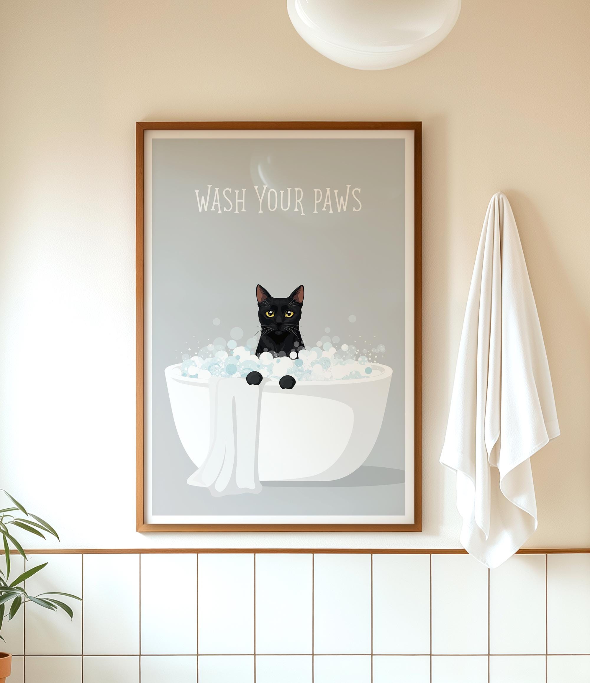 A framed poster with a black cat sitting in a white bathtub filled with bubbles, accompanied by the text "WASH YOUR PAWS" on the poster.