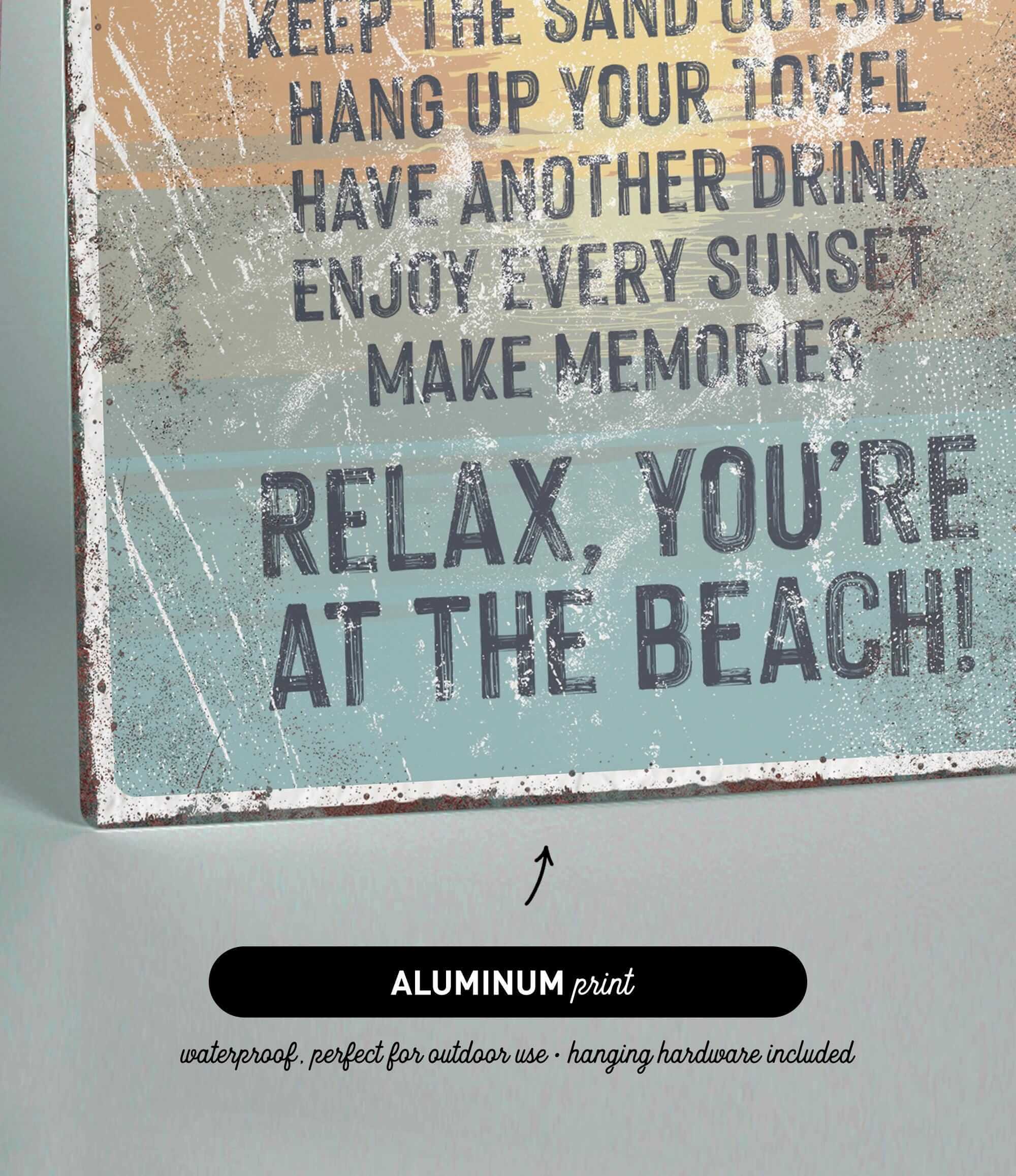 The image is a sign with text that reads "Relax, You're at the Beach!" and it is made of aluminum print.
