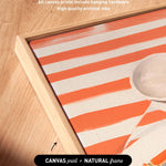 a close-up view of a framed artwork with a striped pattern, placed on a wooden surface.