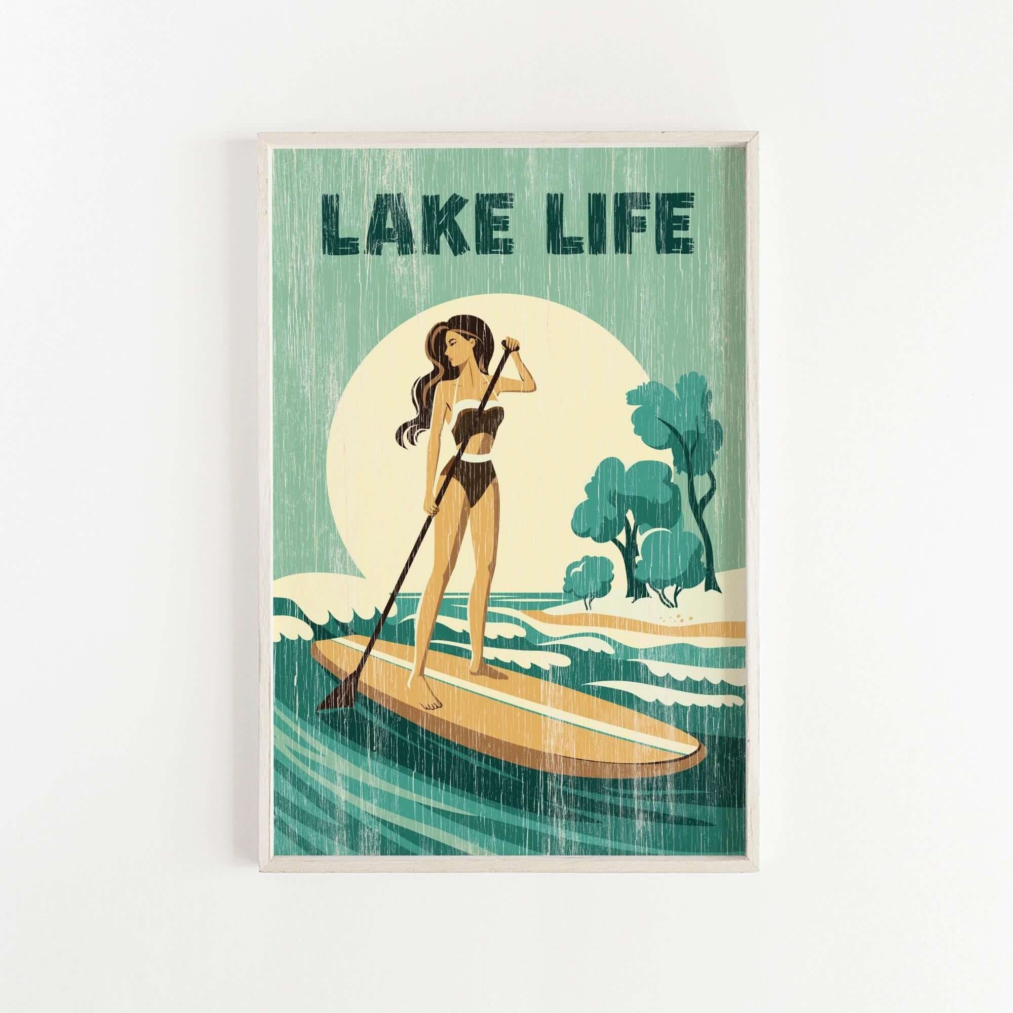 A woman in a bathing suit stands on a paddleboard, holding a paddle and facing a large body of water with trees in the background.