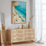 a beach scene with a painting of a beach and turquoise water, a wicker dresser with drawers, and a mirror on the wall.